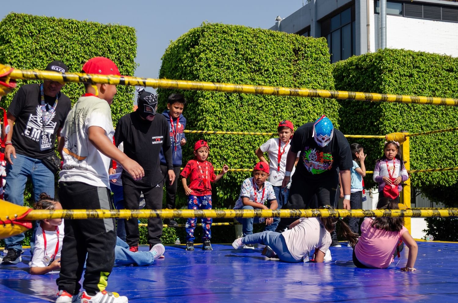 Niños participando en una dinámica sobre el ring junto a luchadores